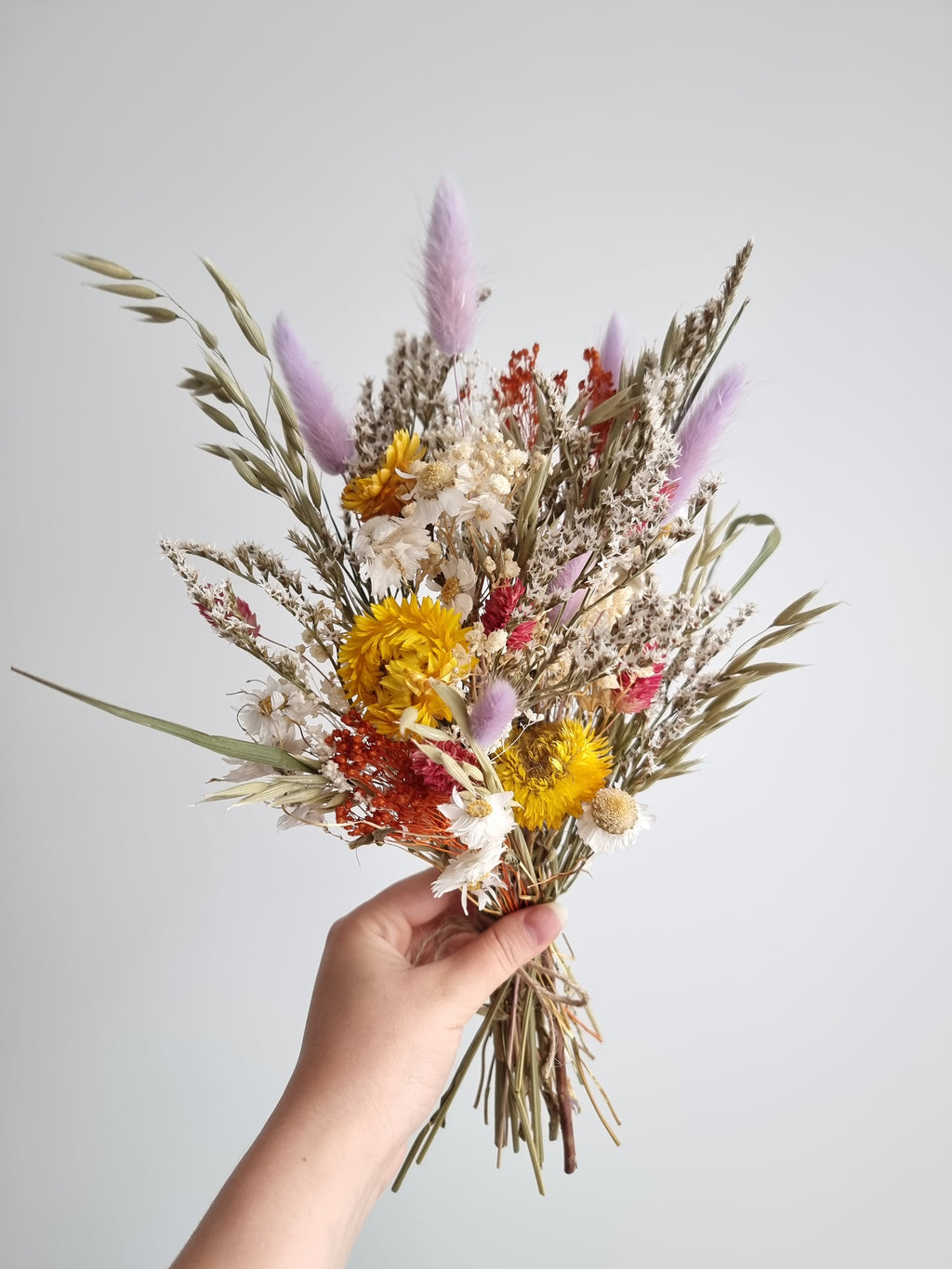 Wildblumenstrauß, Trockenblumen in Pastell-Lila, Gelb und Rot, natürliche Wiesenblumen