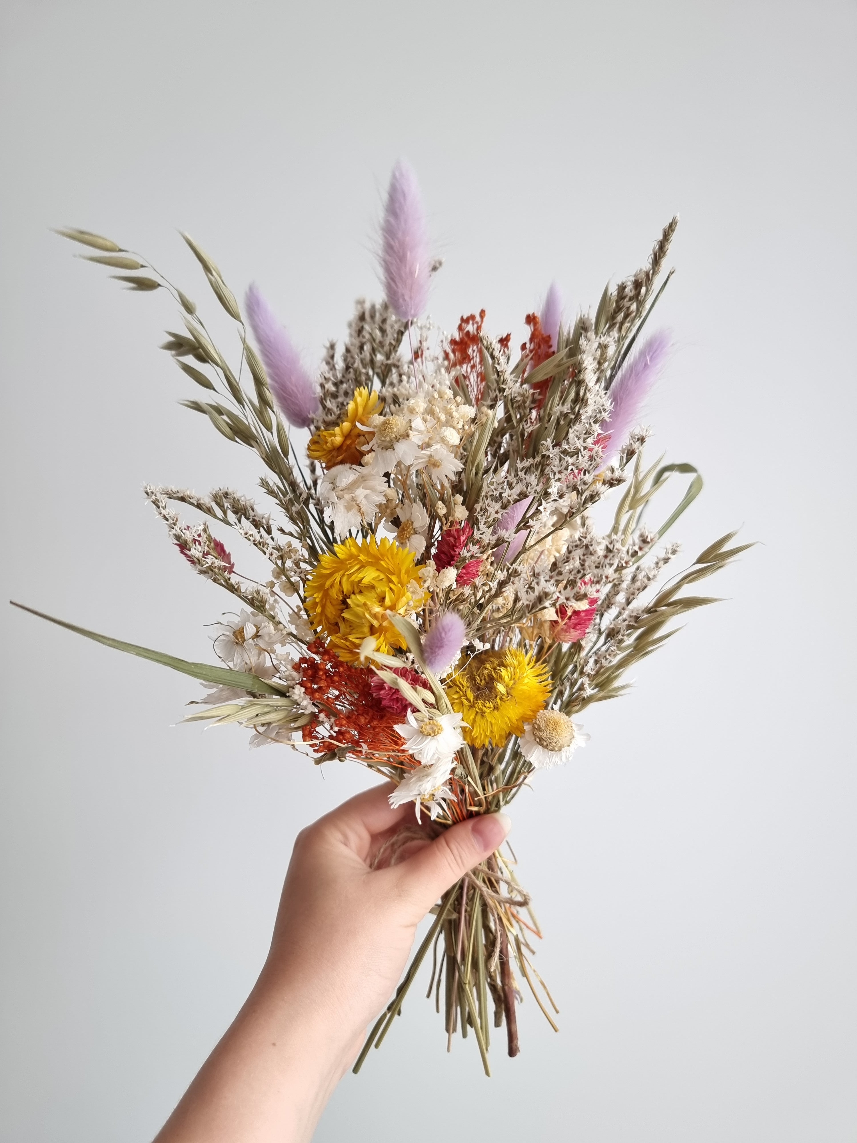 Wildblumenstrauß, Trockenblumen in Pastell-Lila, Gelb und Rot, natürliche Wiesenblumen