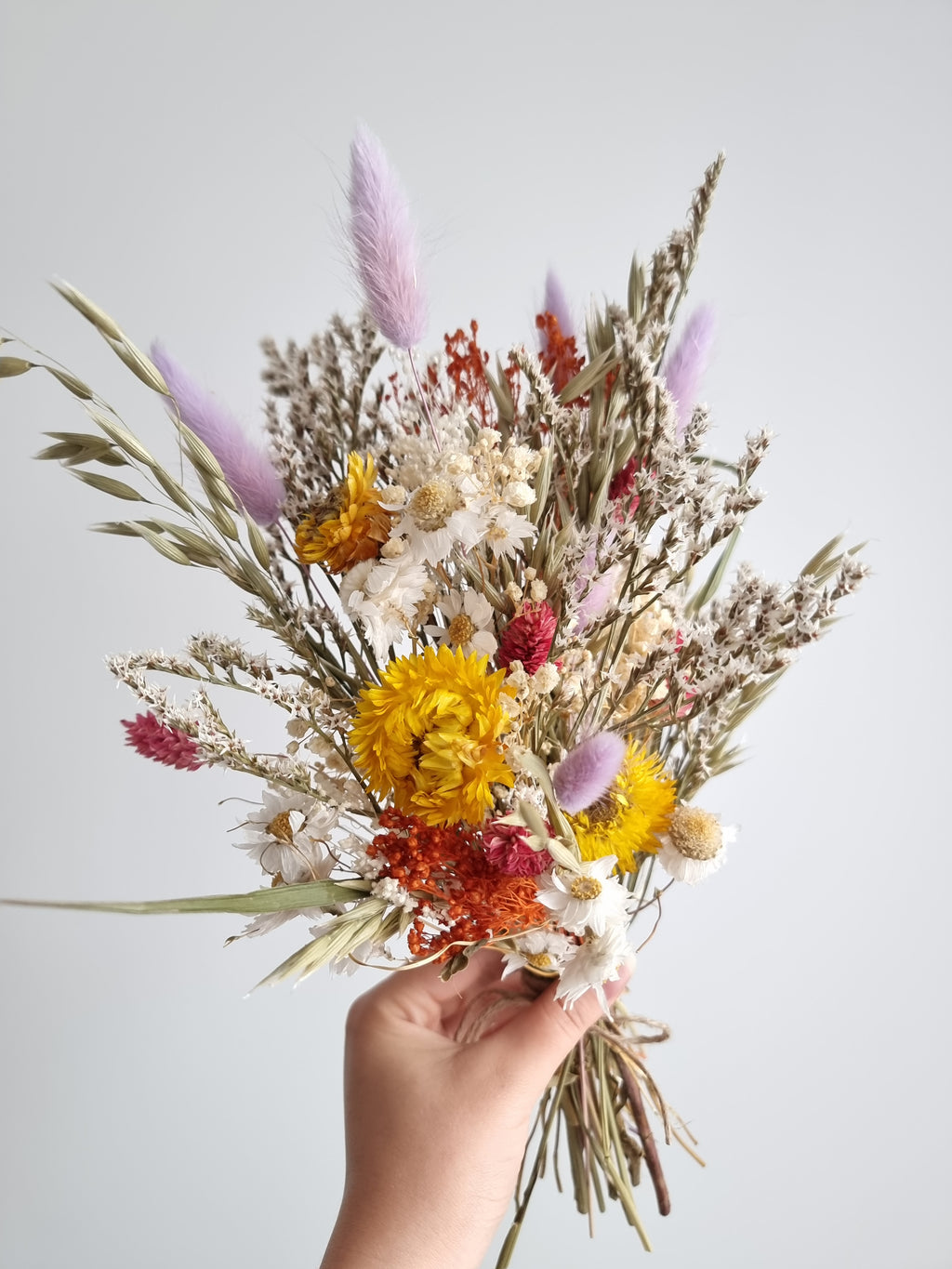 Wildblumenstrauß, Trockenblumen in Pastell-Lila, Gelb und Rot, natürliche Wiesenblumen