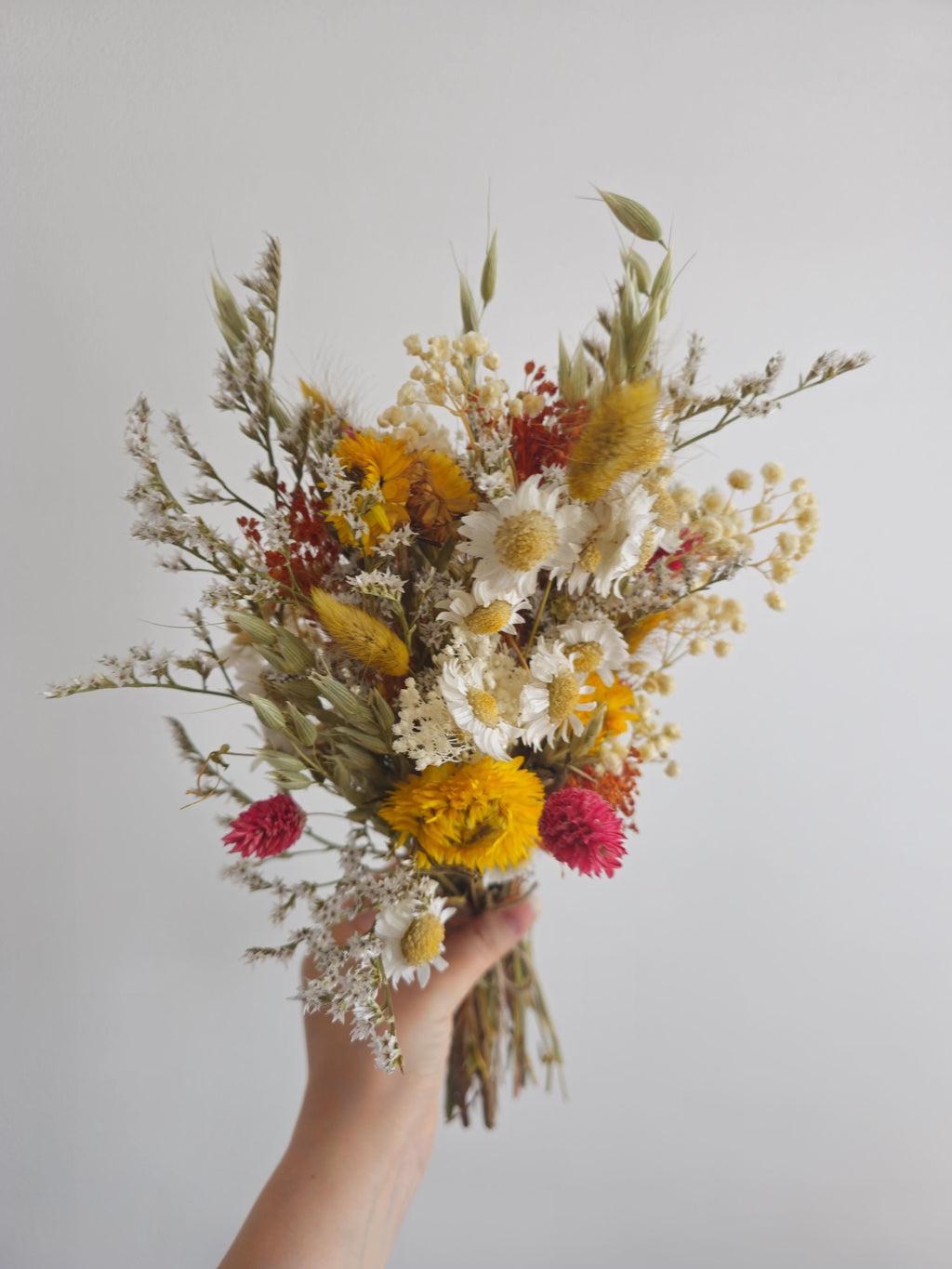 Brautstrauß aus Wildblumen und Gänseblümchen, gelbe, terrakottafarbene Trockenblumen, herbstliches Wiesenblumenarrangement 