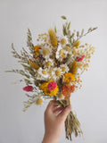 Brautstrauß aus Wildblumen und Gänseblümchen, gelbe, terrakottafarbene Trockenblumen, herbstliches Wiesenblumenarrangement 