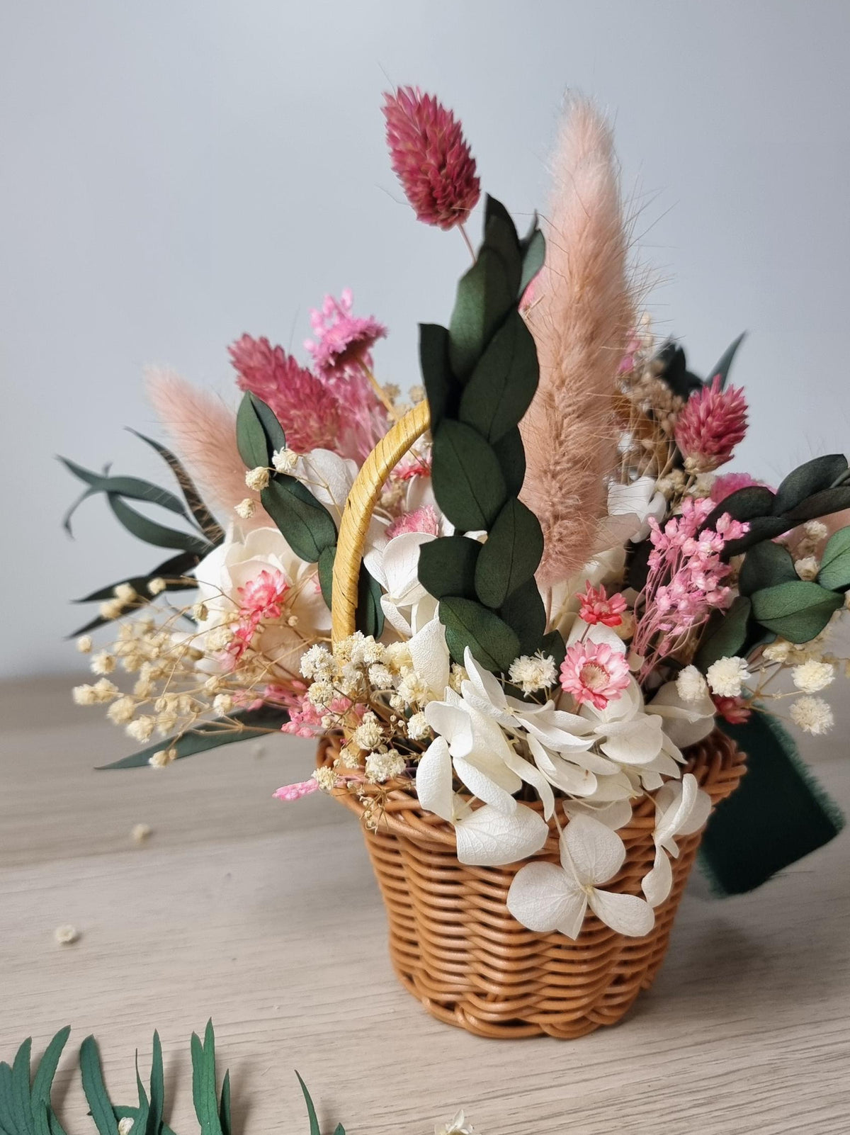 Osterkorb mit rosa Blumen, Blumenarrangement, rustikale Wohndekoration im Cottagecore-Stil