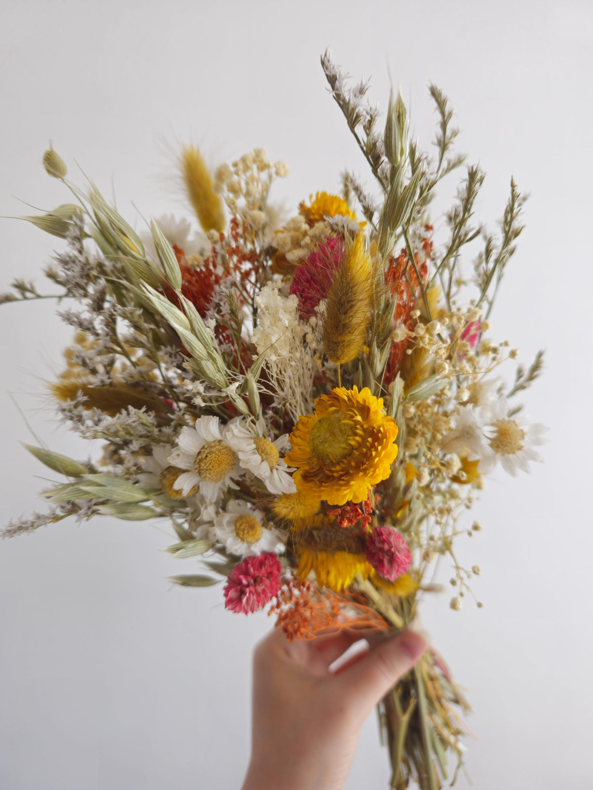 Brautstrauß aus Wildblumen und Gänseblümchen, gelbe, terrakottafarbene Trockenblumen, herbstliches Wiesenblumenarrangement 