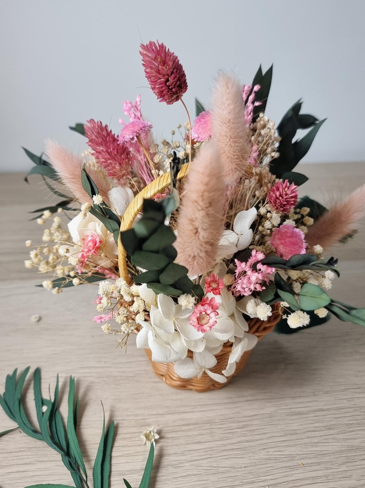 Osterkorb mit rosa Blumen, Blumenarrangement, rustikale Wohndekoration im Cottagecore-Stil