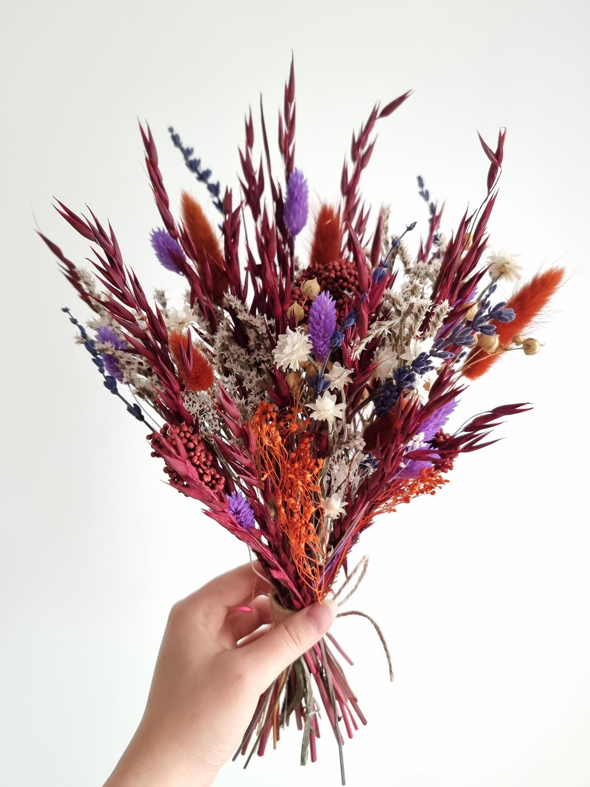 Dramatischer Wildblumenstrauß, tiefrote, terrakottafarbene und violette Trockenblumen, natürliche Wiesenblumen 