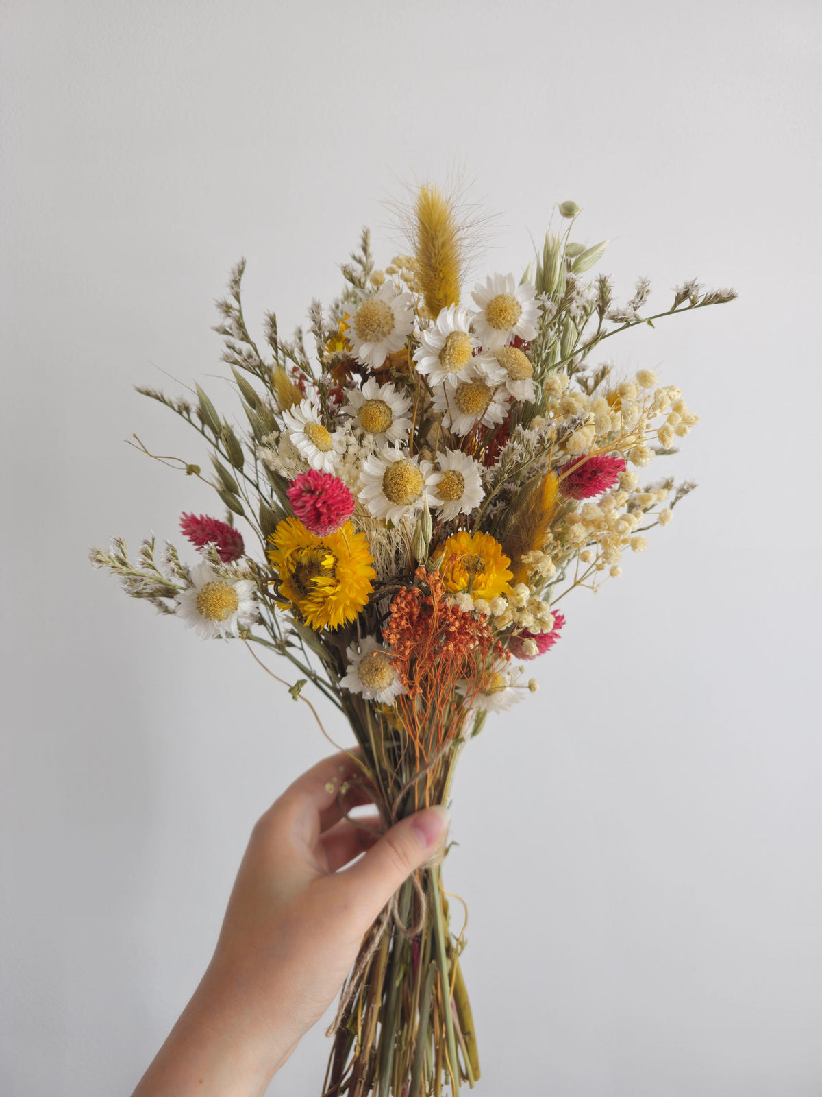 Brautstrauß aus Wildblumen und Gänseblümchen, gelbe, terrakottafarbene Trockenblumen, herbstliches Wiesenblumenarrangement 