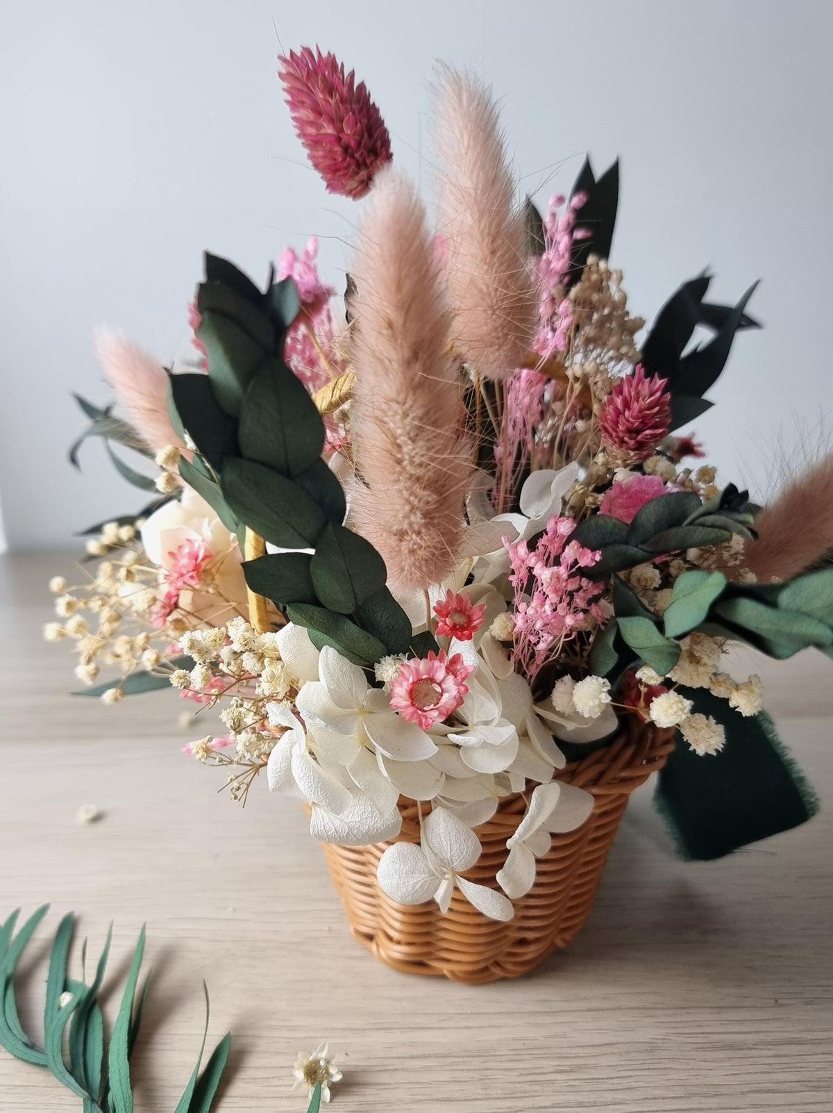 Osterkorb mit rosa Blumen, Blumenarrangement, rustikale Wohndekoration im Cottagecore-Stil