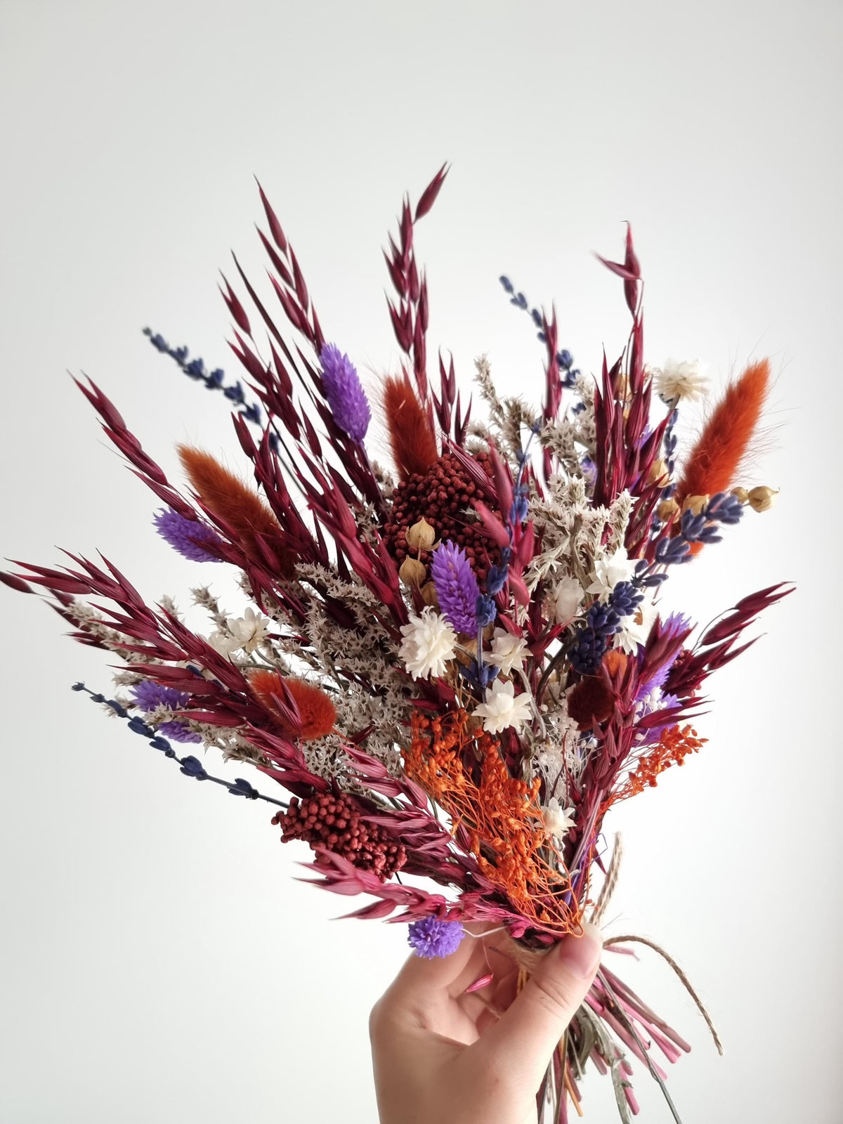 Dramatischer Wildblumenstrauß, tiefrote, terrakottafarbene und violette Trockenblumen, natürliche Wiesenblumen 